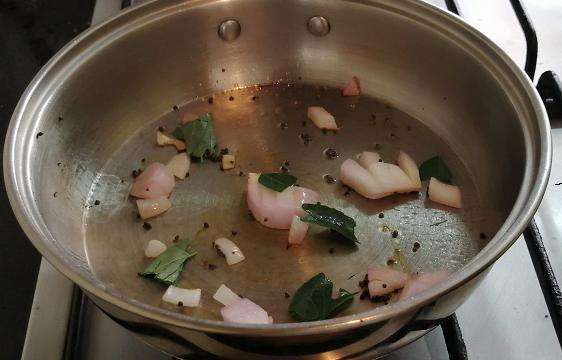 Take a pan and add in oil, chopped onion, curry leaves.