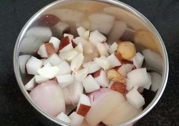 Take a jar and add in onion, chopped coconuts, ginger and garlic cloves.