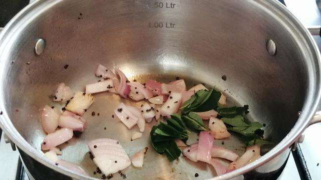 Take another pan and add in oil mustard seeds, chopped onion, and curry leaves.