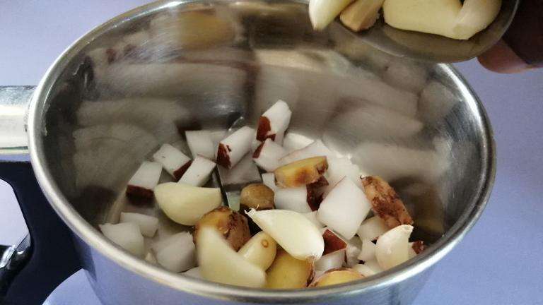 Take a mixer jar and add in chopped coconuts, ginger and garlic cloves.