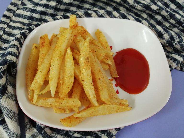 Yummy French fries is ready to serve with tomato ketchup.