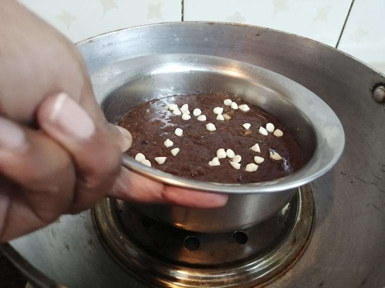 Sprinkle some white choco chips and then place the cake mold into the pan and close the lid and allow to bake for 30 to 35 minutes,