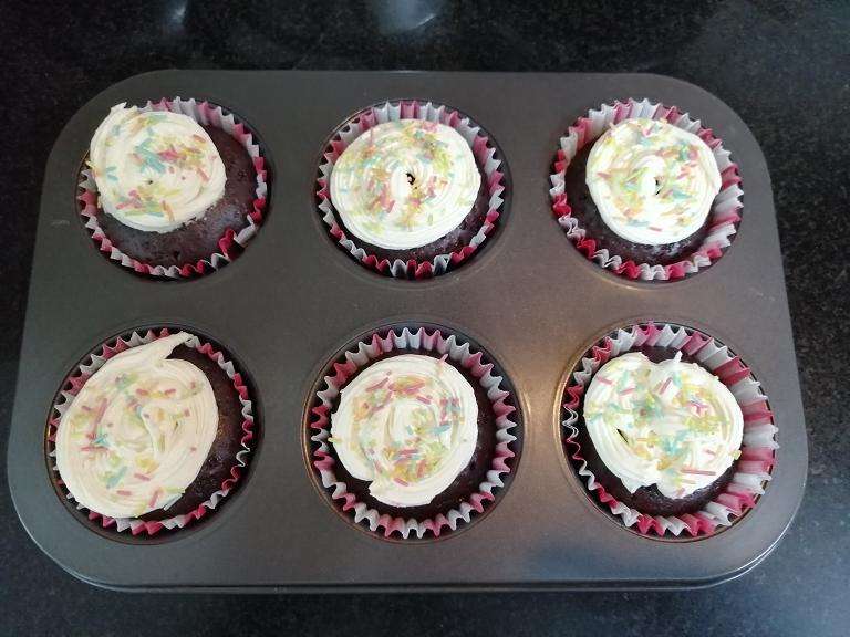 Now decorate the cakes with frosting and with some sprinklers, then the red velvet cup cakes are ready to serve.