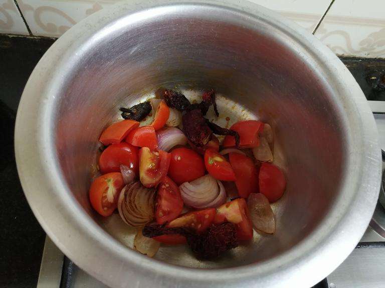 Take a pan and add in 2 tbsp oil, 1 onion, 2 kashmiri chili, 3 tomato, 2 cloves, 1 cardamom, 5 pepper corns. Fry till gold brown.