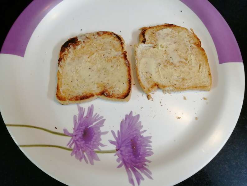 Spread garlic butter on toasted bread.