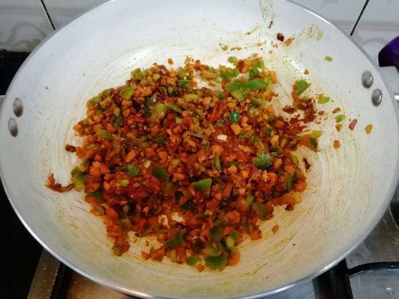 Add in chili powder, coriander powder, garam masala, finely chopped carrots, and capsicums. Close the lid and cook for five minutes in low flame.