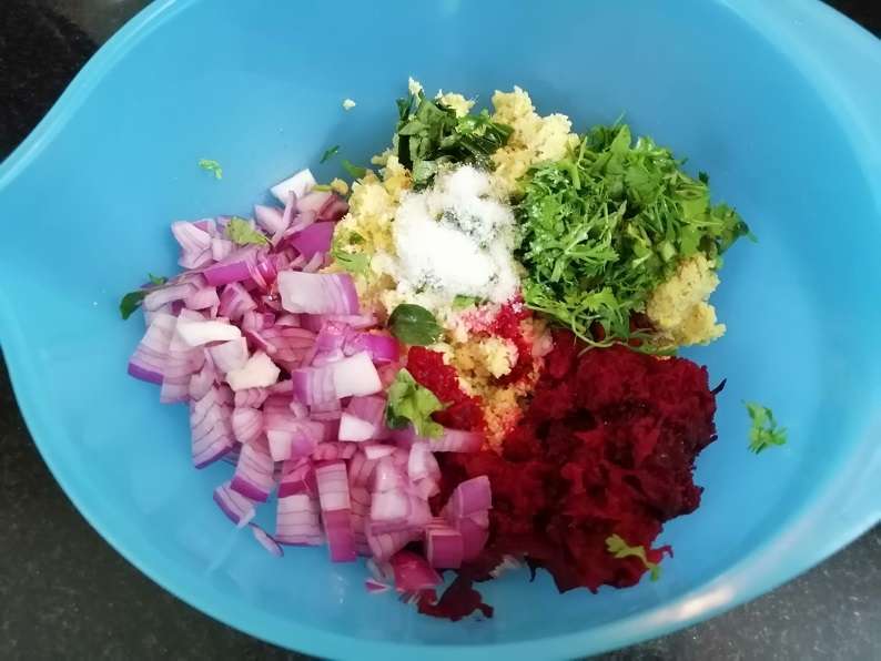 Take a mixing bowl and add in coarsely ground mix, grated beetroot, chopped coriander leaves, chopped onions, chopped curry leaves, salt to taste.