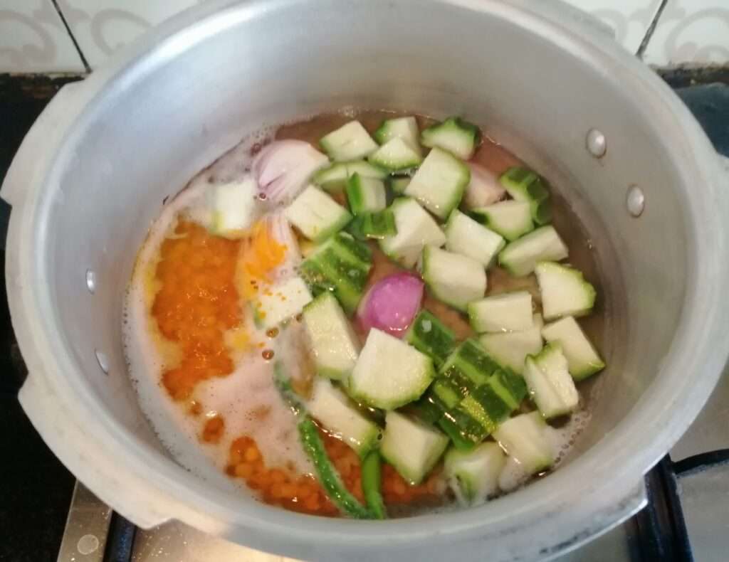 Now add in turmeric powder, ridge gourd and salt. Pressure cook it for 3 to 4 whistles.