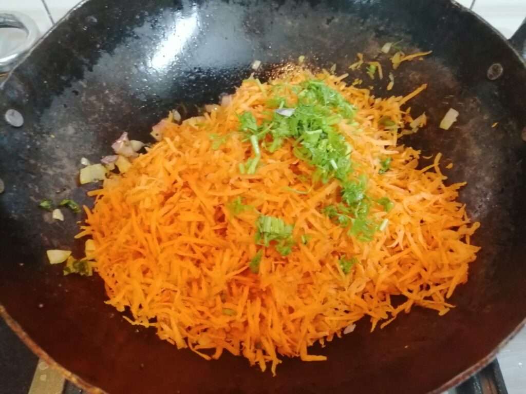 Now add in grated carrot and give a mix. Finally garnish it with some chopped coriander leaves.